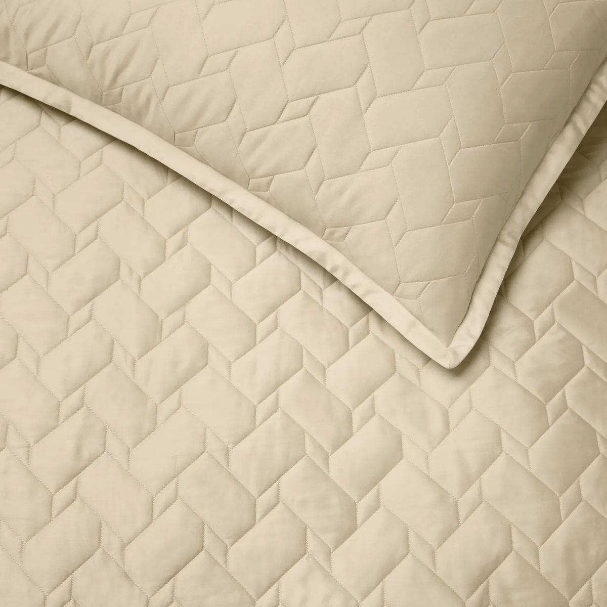 Close-up of Sand Sferra Palatino Quilt and Shams, both featuring a crisp geometric, textured pattern