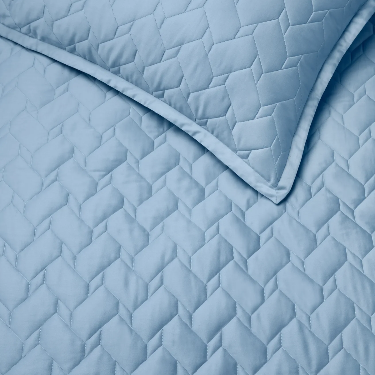 Close-up of Sea Sferra Palatino Quilt and Shams, both featuring a crisp geometric, textured pattern