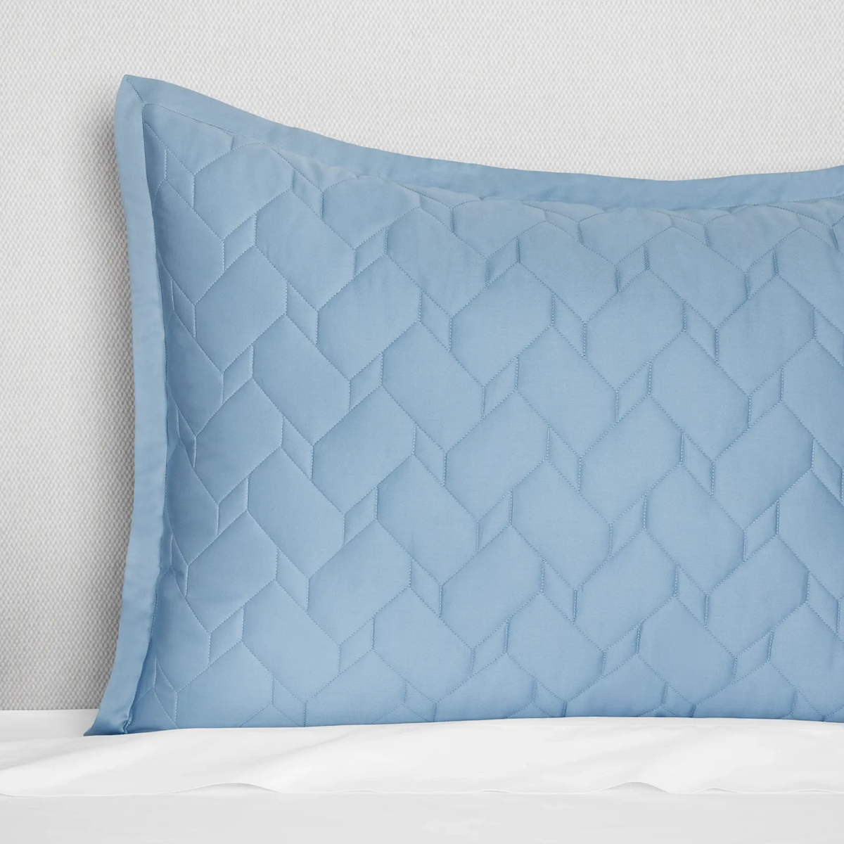 A Sea Close-up of Sferra Palatino Sham, featuring a crisp geometric pattern