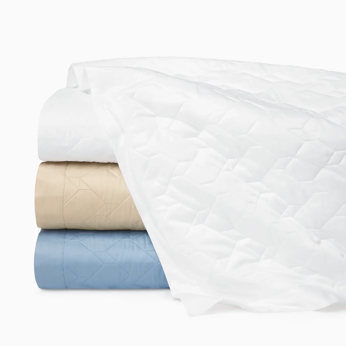 Three folded Sferra Palatino Quilt in White, Sea and Sand, and are stacked