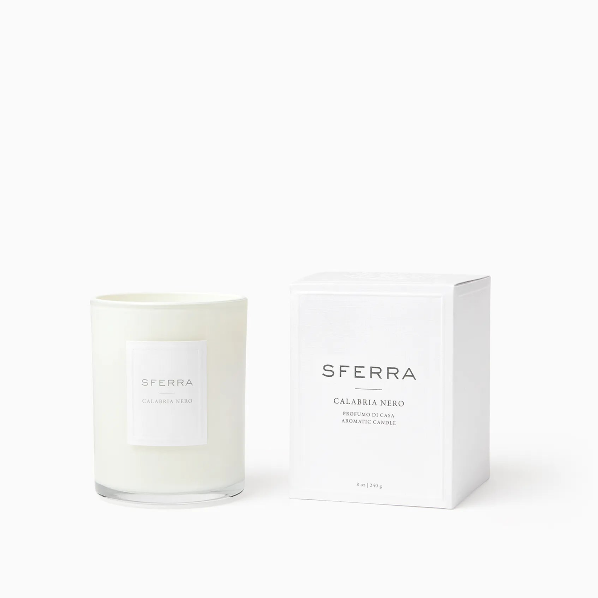 A white SFERRA candle in a glass jar, part of the Sferra Profumo di Casa luxury home scents, beside its Calabria Nero box.