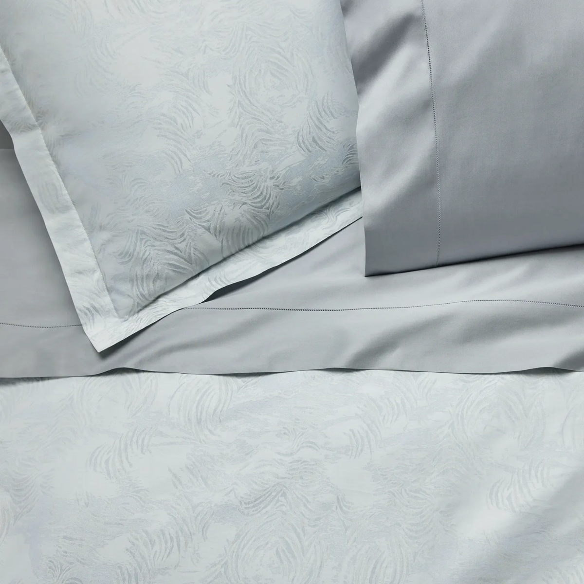 Closeup of Sferra Riflesso Duvet Cover and Shams with SFERRA Giza 45 Sateen Tin sheet