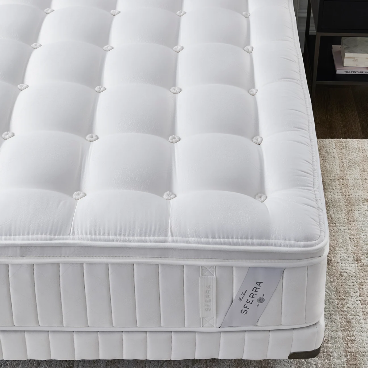 White, tufted Sferra Sonno Notte CV Pillowtop Mattress with quilted surface; displayed on a bed beside a nightstand.