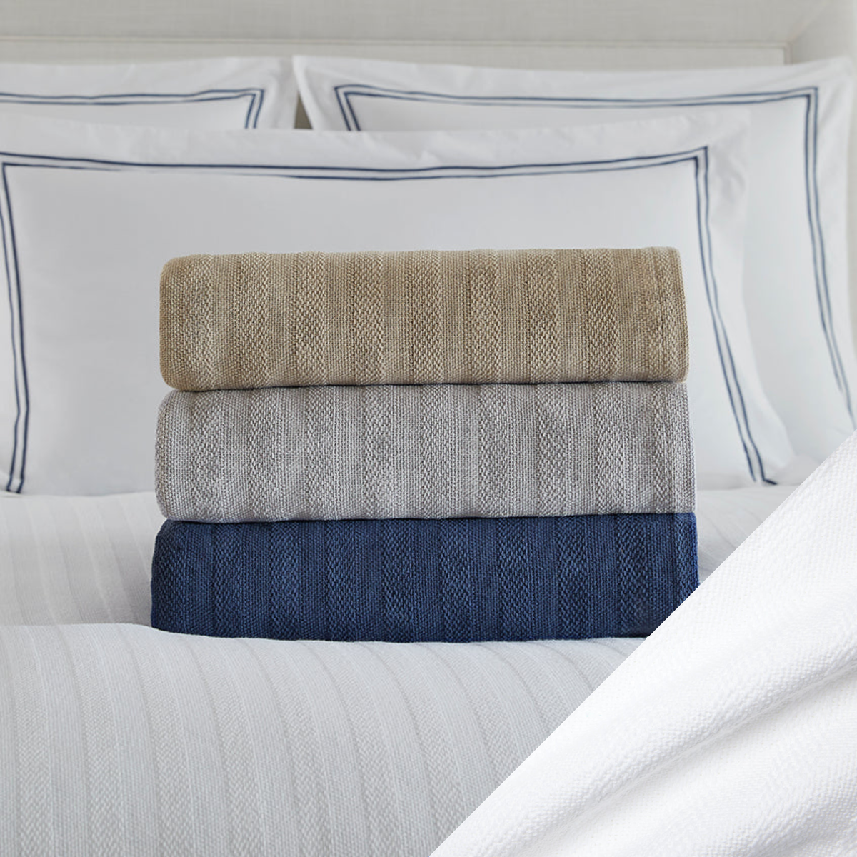 Stack of Folded Sferra Tavira Blanket on a Bed with White Swatch