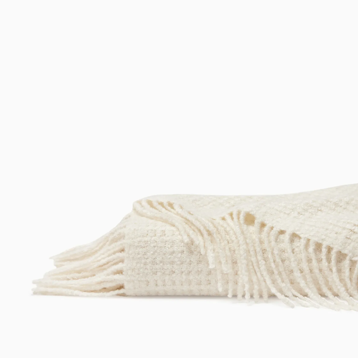 Folded Sferra Terranova Throw in Ivory color showing its twisted fringes