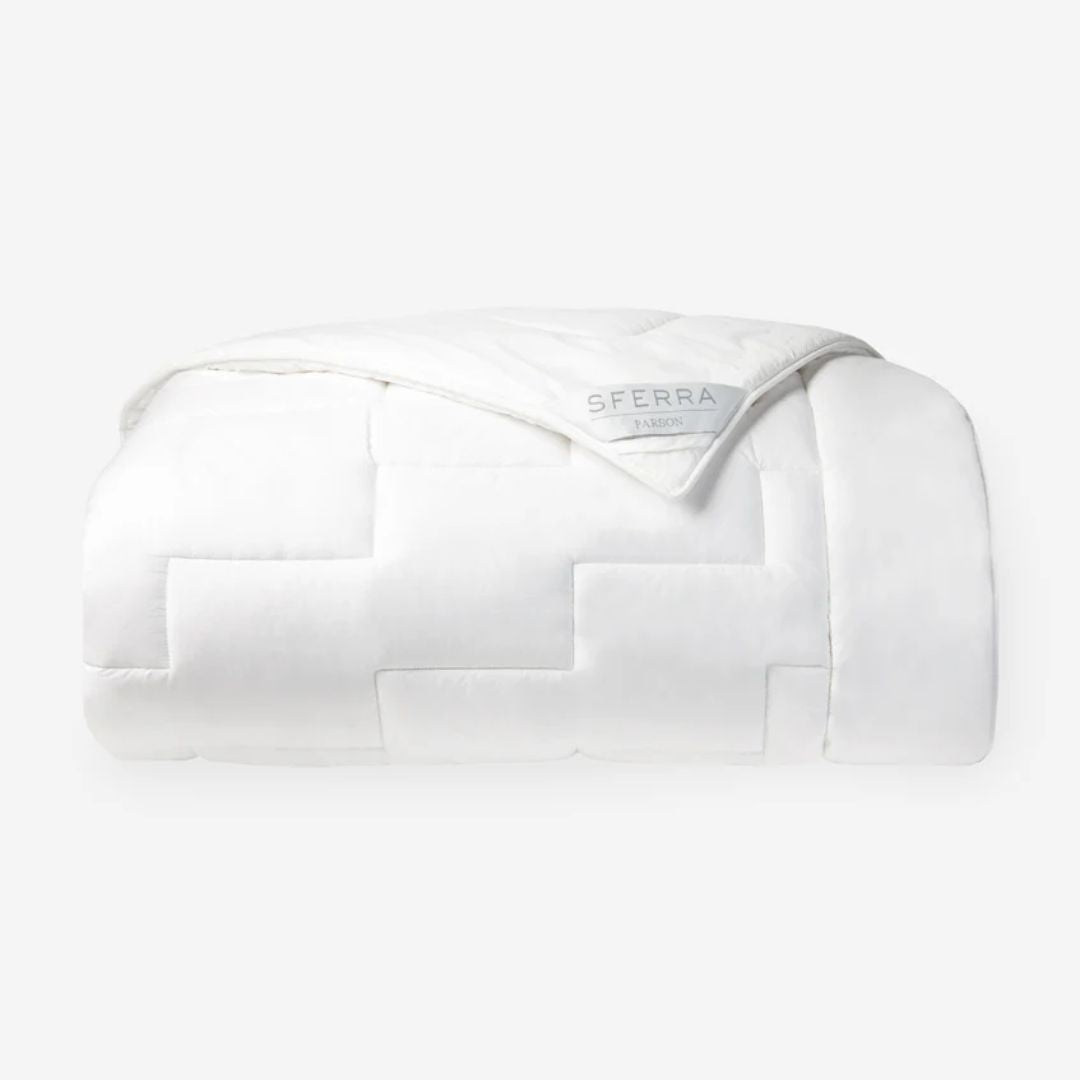 A neatly folded white down alternative duvet with a visible SFERRA label on a plain white background.