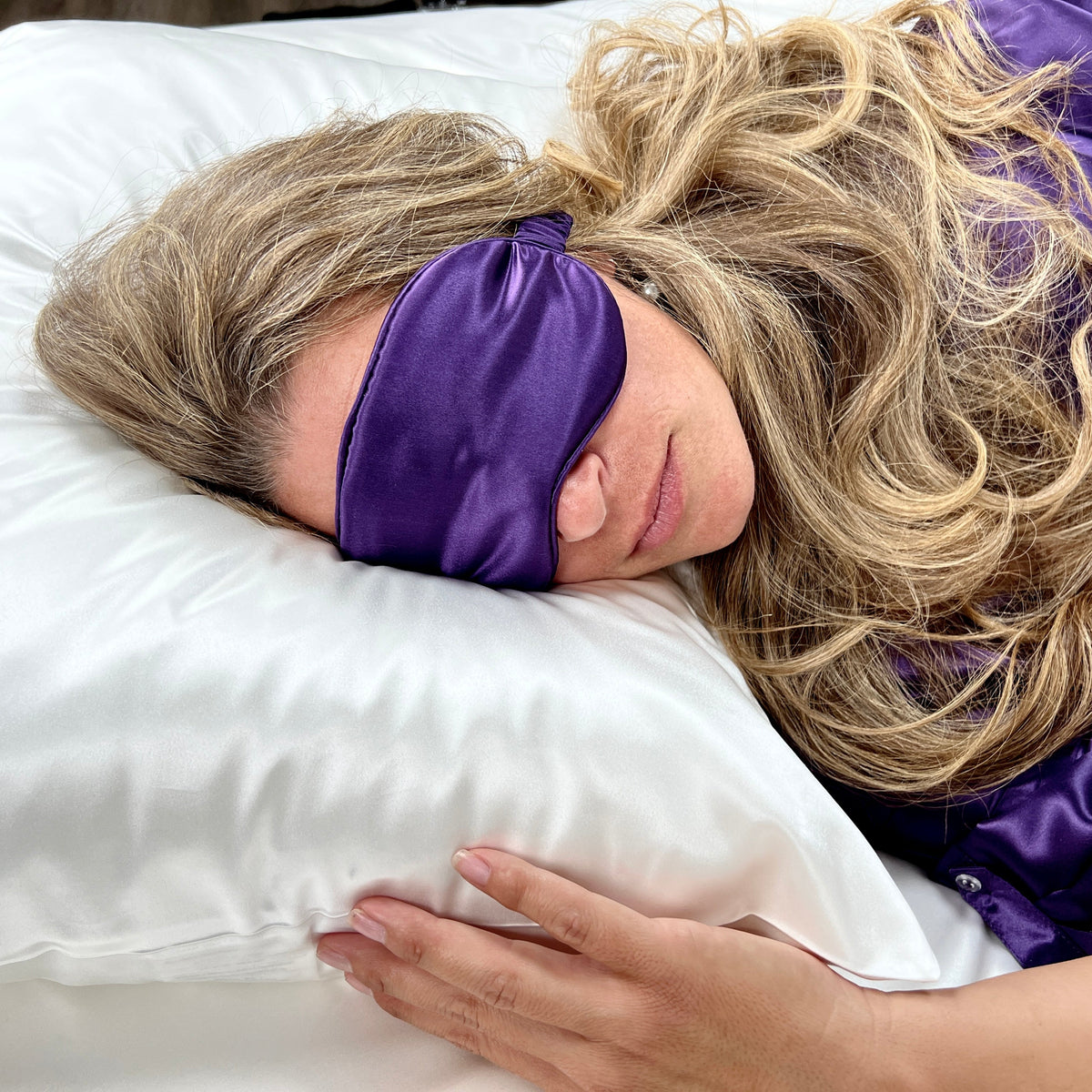 Woman sleeping on a white pillow with a Plum silk sleep mask for eyes for ultimate comfort