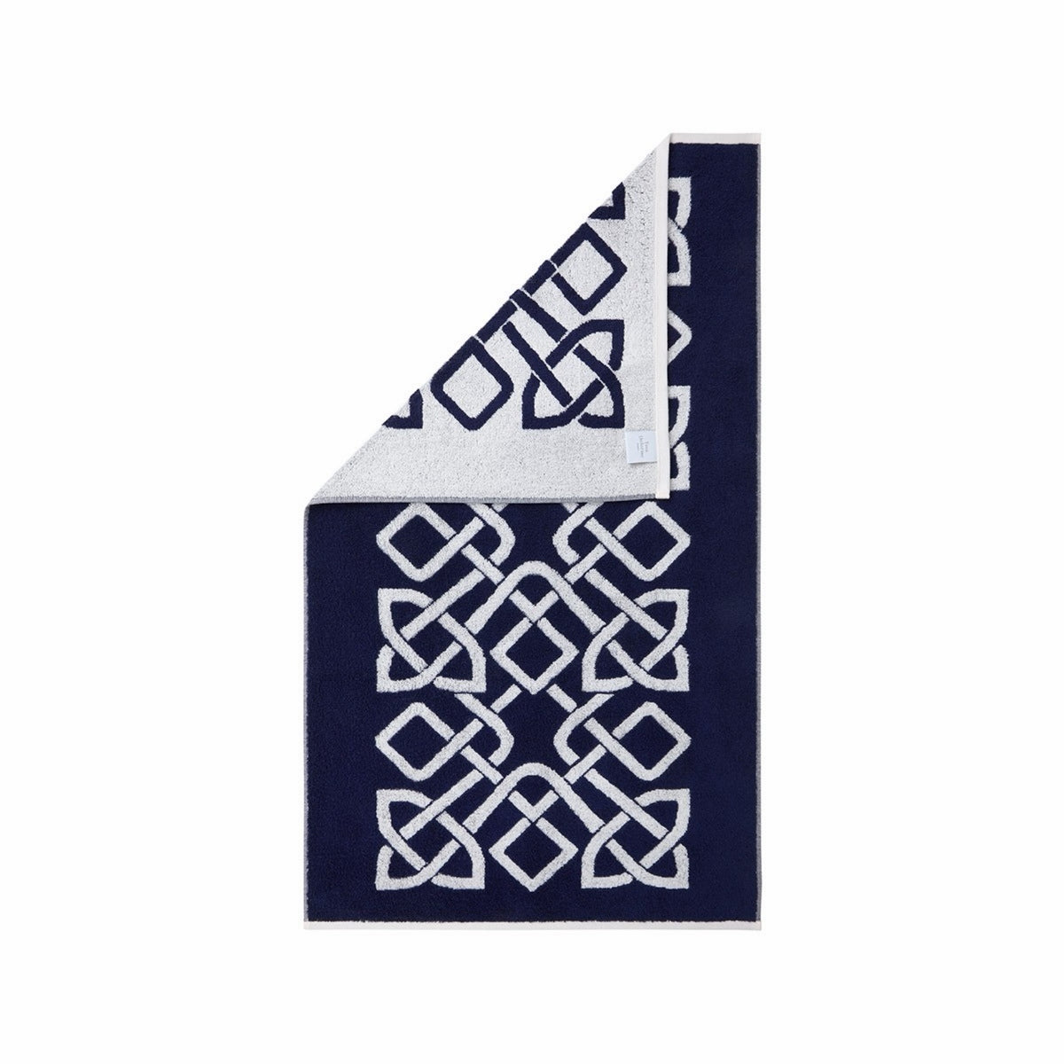 Rectangular Yves Delorme Apollon Bath Towel in Marine color and white knot pattern, corner folded to show reverse design