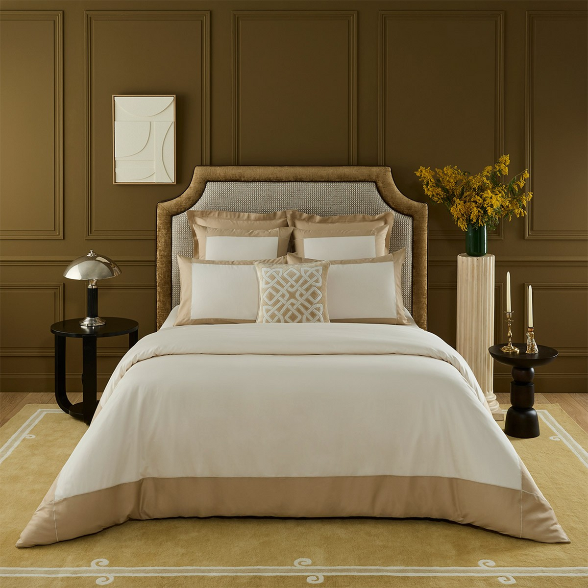 A neatly made bed with Yves Delorme Apollon Bedding Collection in Dune Color