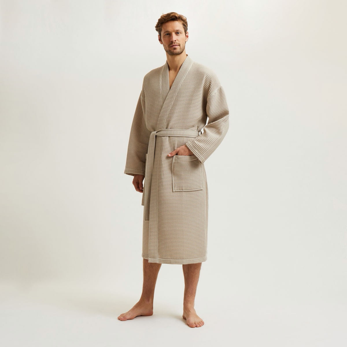 Man standing barefoot in a Pierre Yves Delorme Astreena Bath Robe against a plain light background