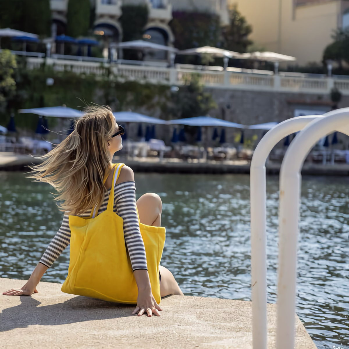 Sitting Woman with Yves Delorme Croisiere Beach Bag in Riviera