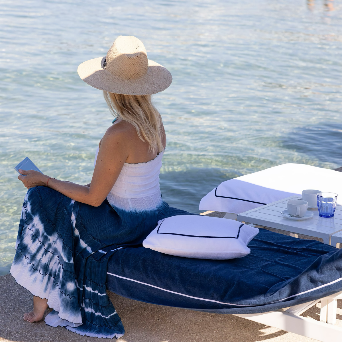 Woman on beach with Yves Delorme Croisiere Beach Pillow in Blanc