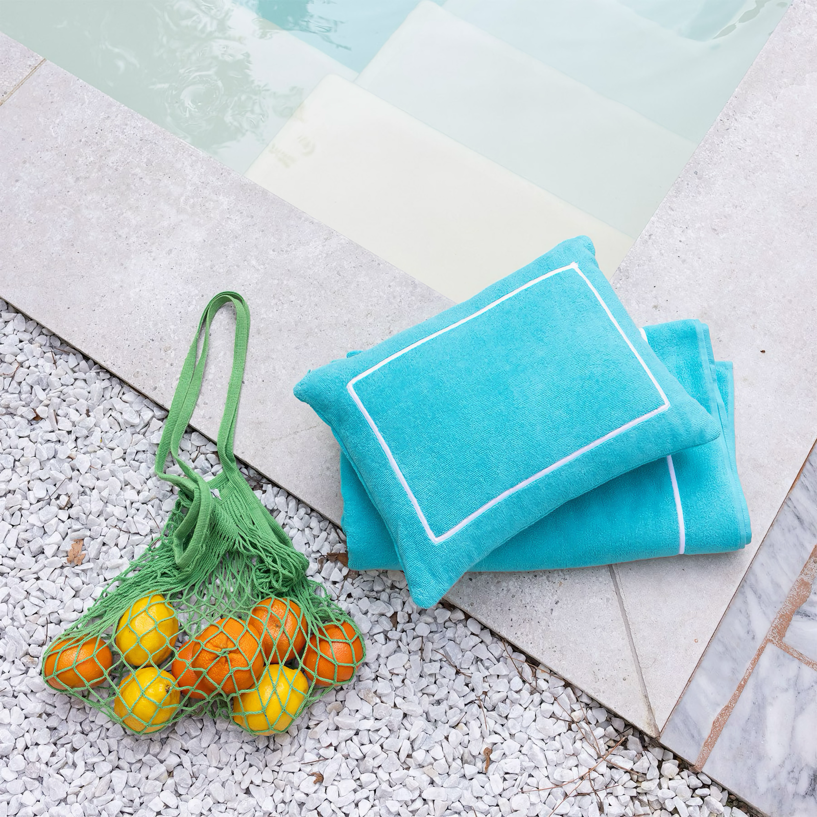 Yves Delorme Croisiere Beach Pillow in Caraibe on floor 