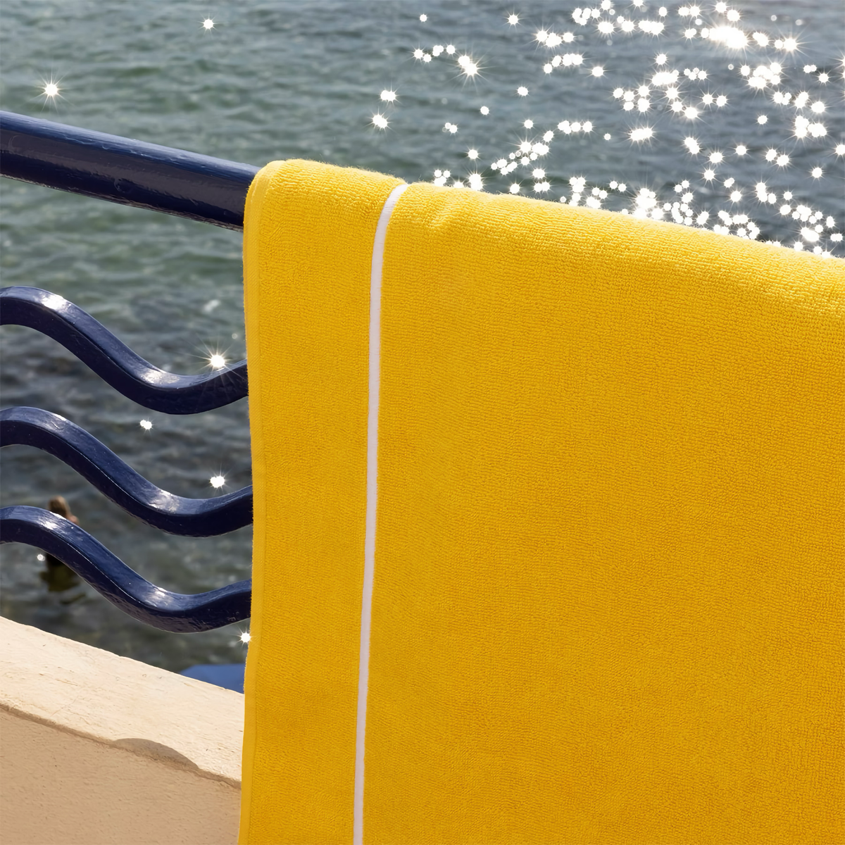 Yves Delorme Croisiere Beach Towel in Riviera with Sea background