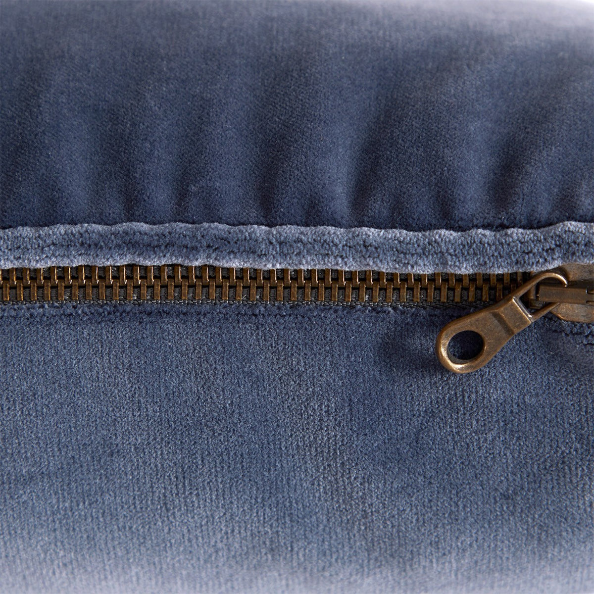 A close-up of a metal zipper on a Yves Delorme Divan Decorative Pillows in Mystere color
