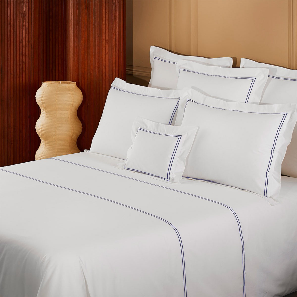 Corner view of bed with Yves Delorme Duo Bedding with Outremer lining