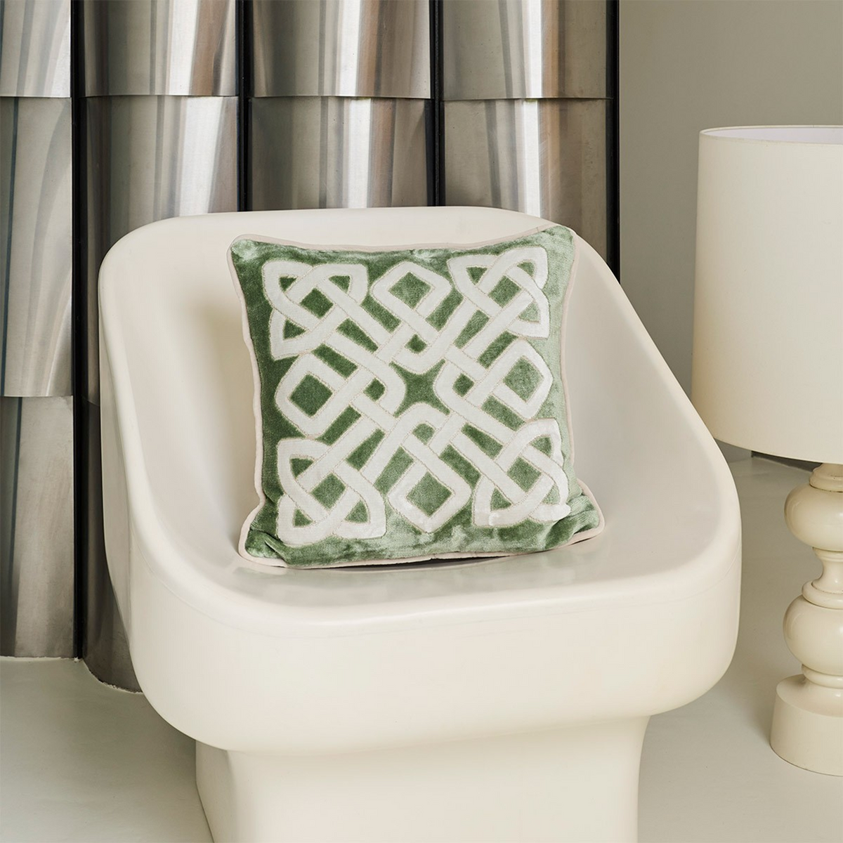 Decorative Pillow of Yves Delorme Entrelac Veronese Bedding Collection on a modern White chair