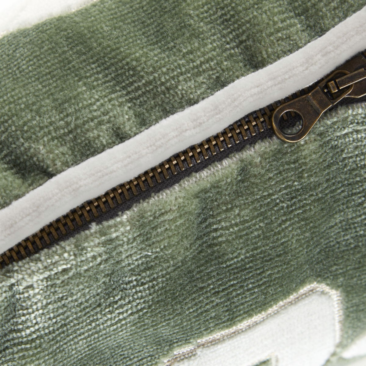 Close-up of a Genoa velvet pillow with a metal zipper.