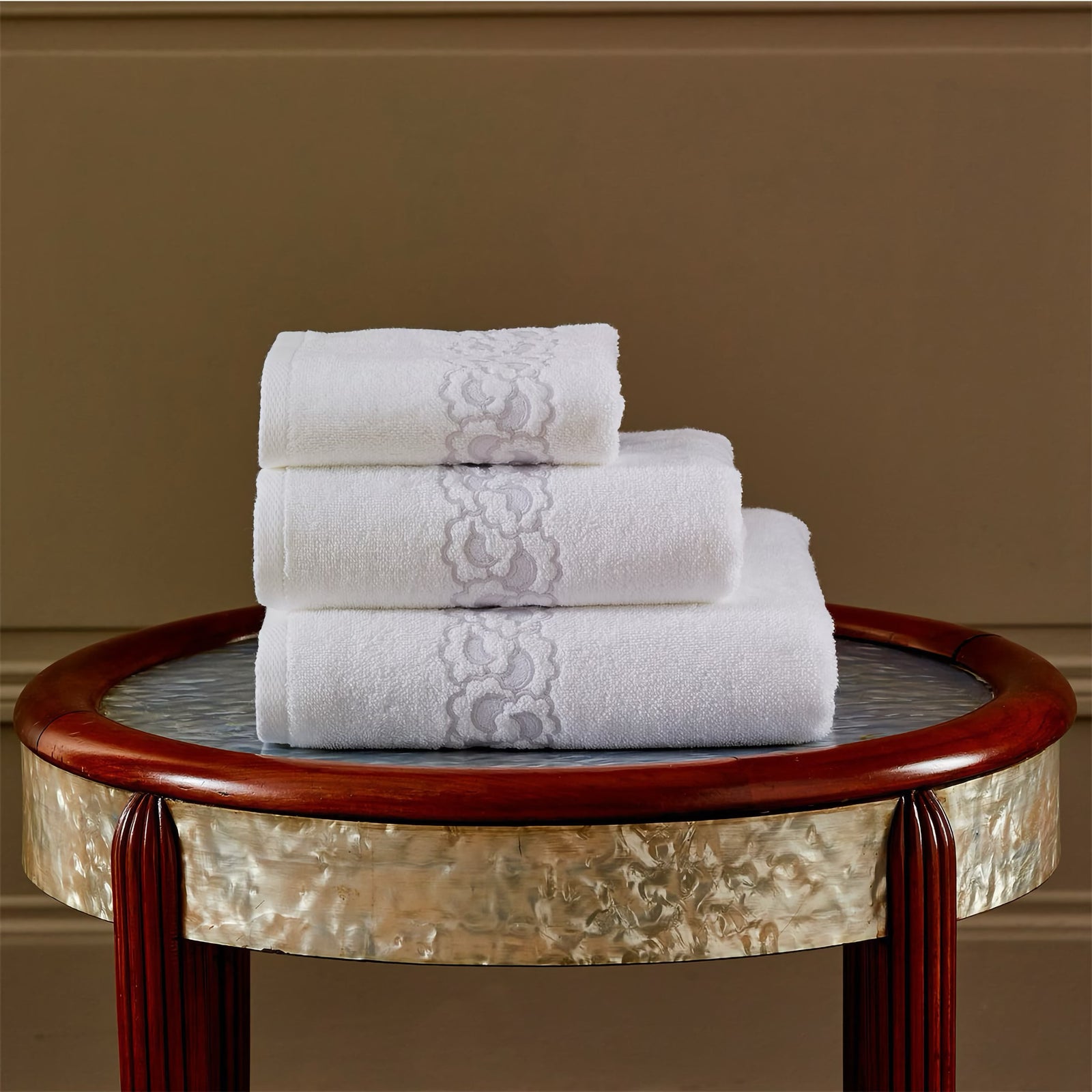 Stack of Yves Delorme Festons Bath Towels on a stool