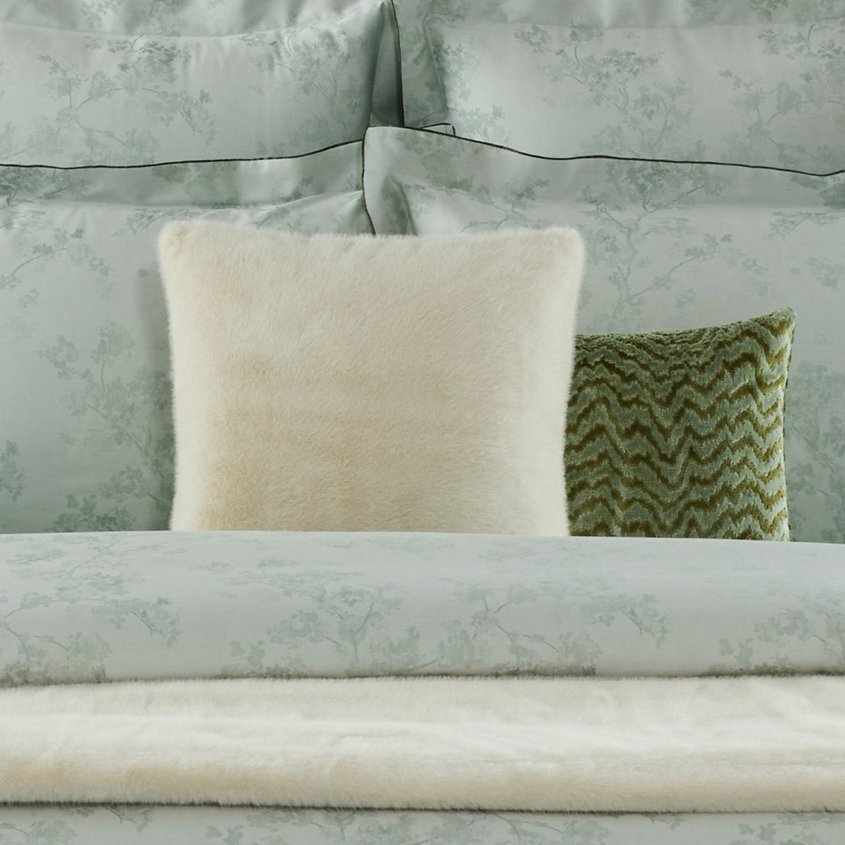 Neige Yves Delorme Frisson Decorative Pillow at the center of a bed