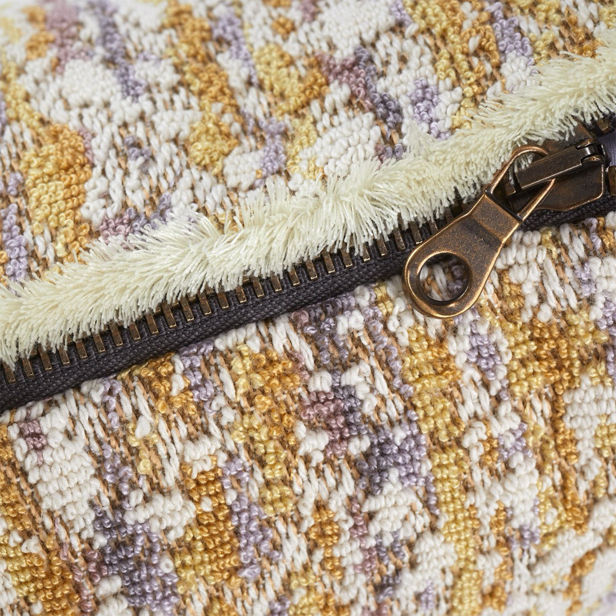 Close-up of the zipper on Yves Delorme Illusion decorative pillows in Orge