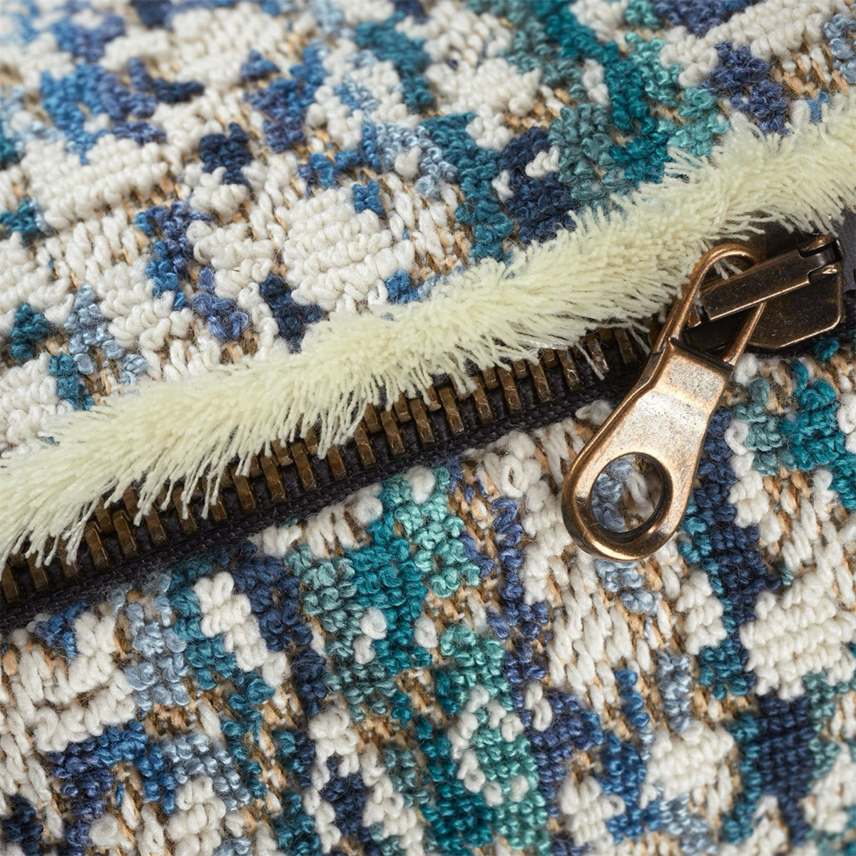 Close-up of the zipper on Yves Delorme Illusion decorative pillows in Paon