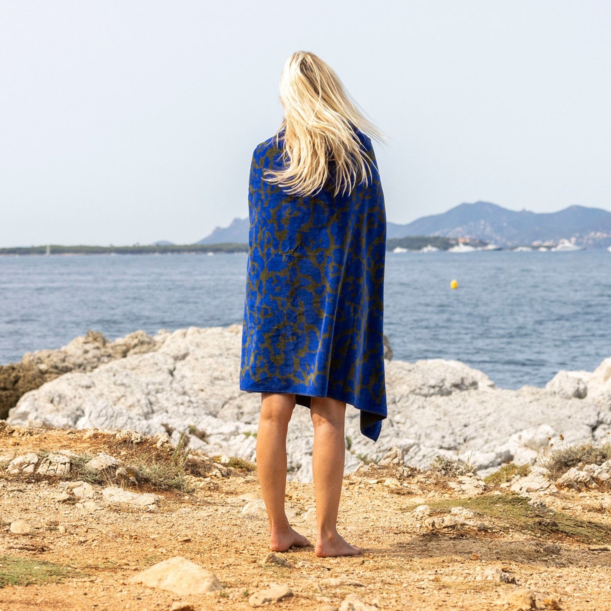 Lifestyle Shot of Yves Delorme Jaguar Beach Towel in Color Indigo