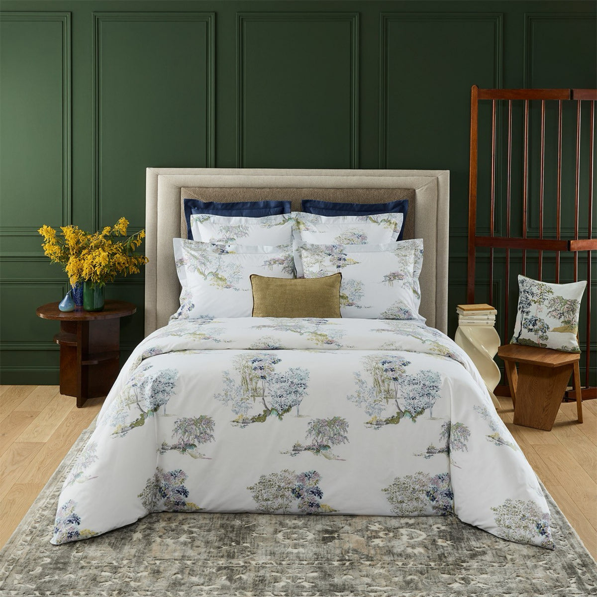 Bed arranged with Yves Delorme Lande Bedding Collection and Aura Decorative Pillow at the center