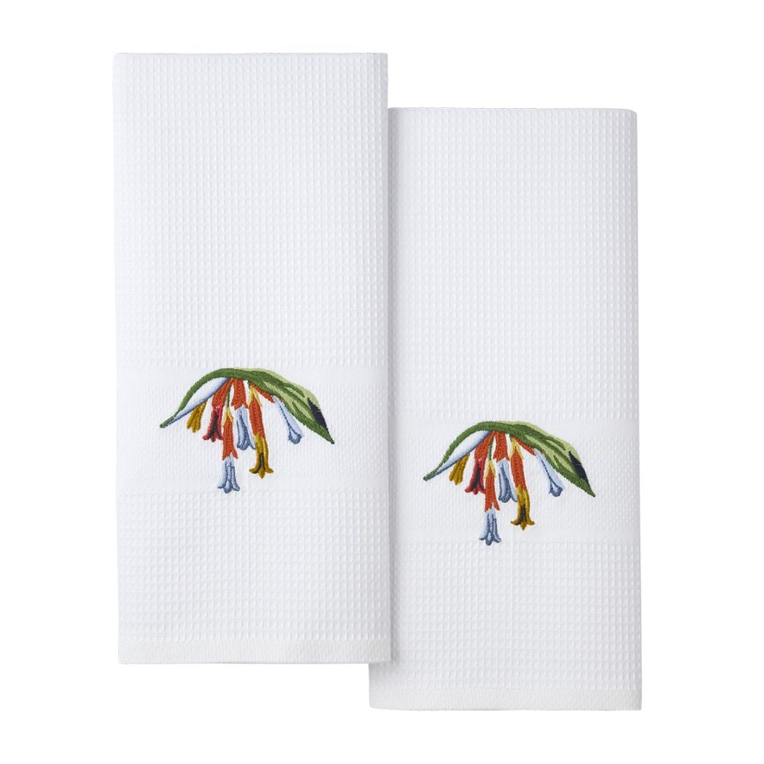 Two white organic cotton bath towels, each with an embroidered cluster of colorful flowers and green leaves near one end.