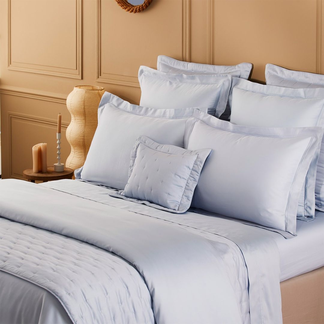 bed showing Yves Delorme Triomphe Bedding in Celeste, both quilted and sheeting styles