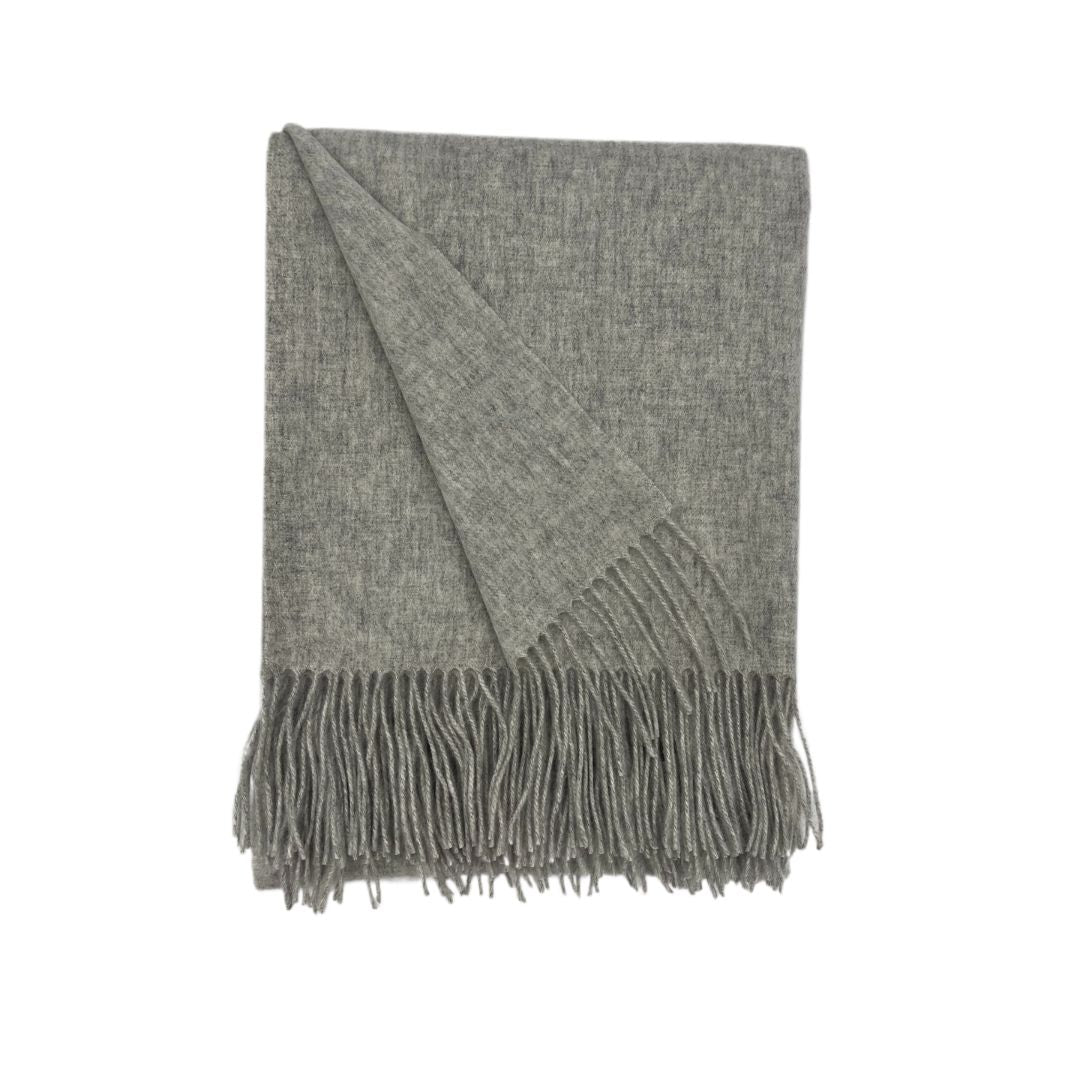 Folded gray fringed woven blanket or throw, with one corner turned over, shown on a plain white background.