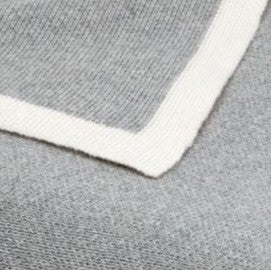Gray luxury Merino wool knit blanket with a thick white border.