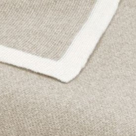Luxury cashmere silk throw in beige knit with a thick white border.