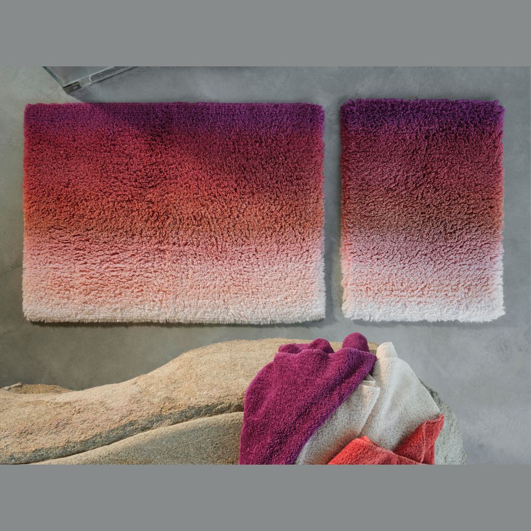 Two gradient bath mats with a towel on a stone surface - Aurore bath rugs side by side