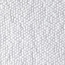 Close-up of a white textured bath rug surface made up of small, tightly packed round foam beads.
