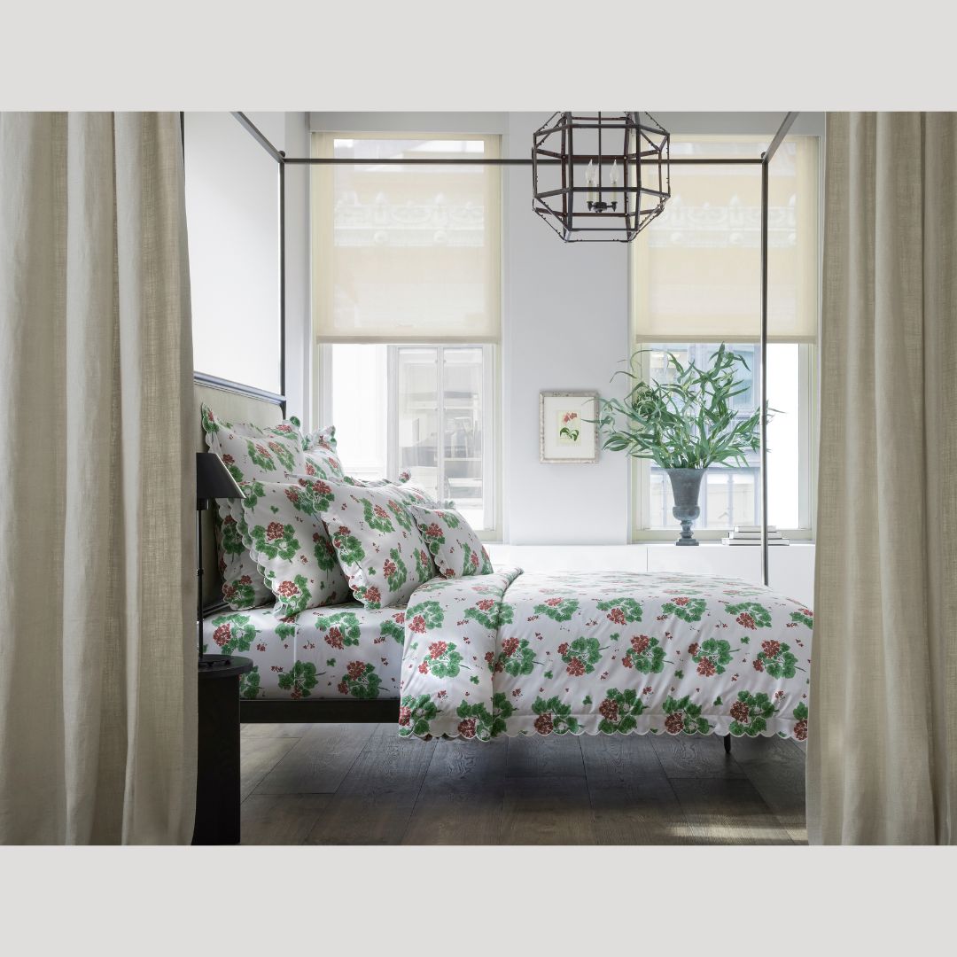 Bedroom with floral bedding and curtains, featuring a large window.