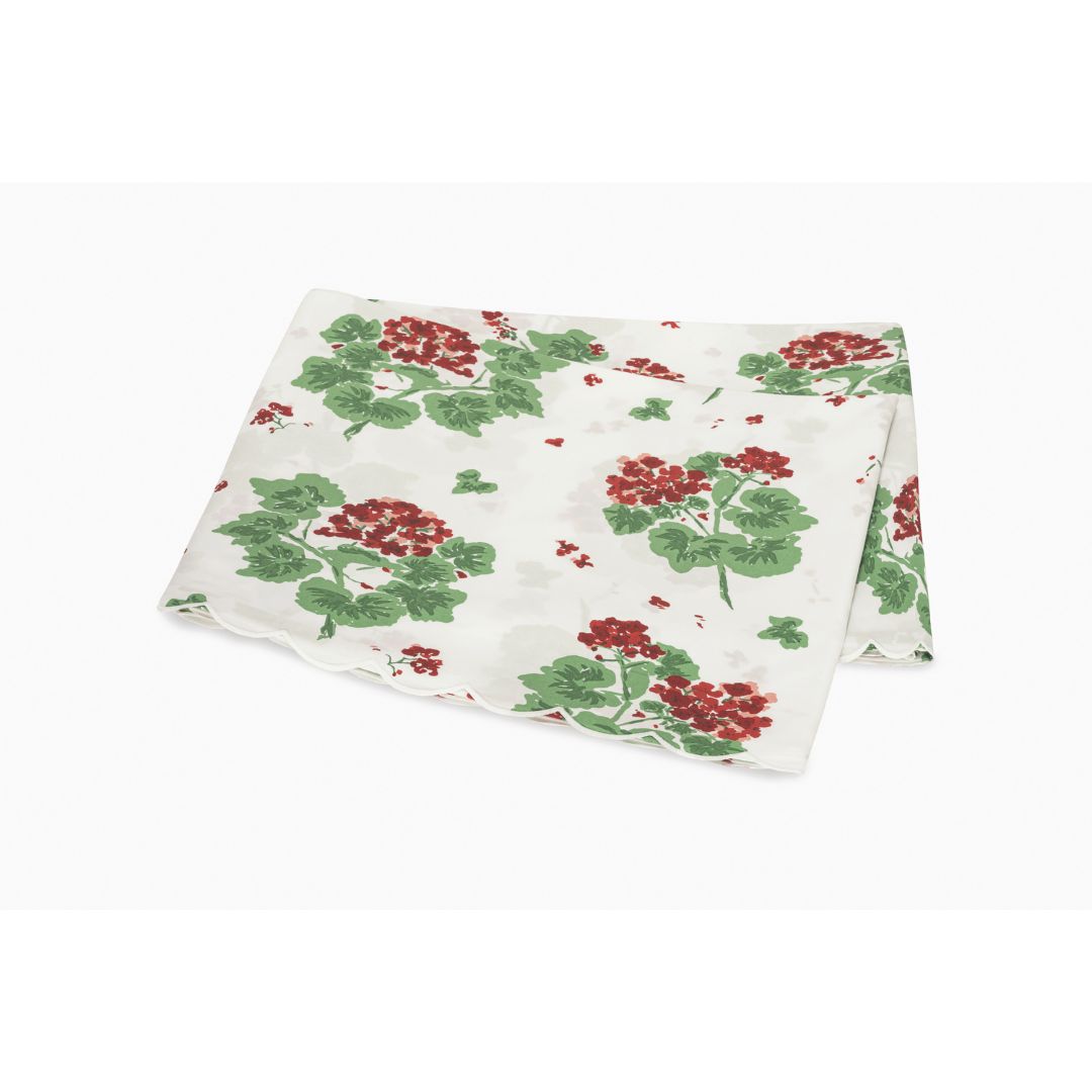 Floral patterned flat sheet with red flowers and green leaves on a white background