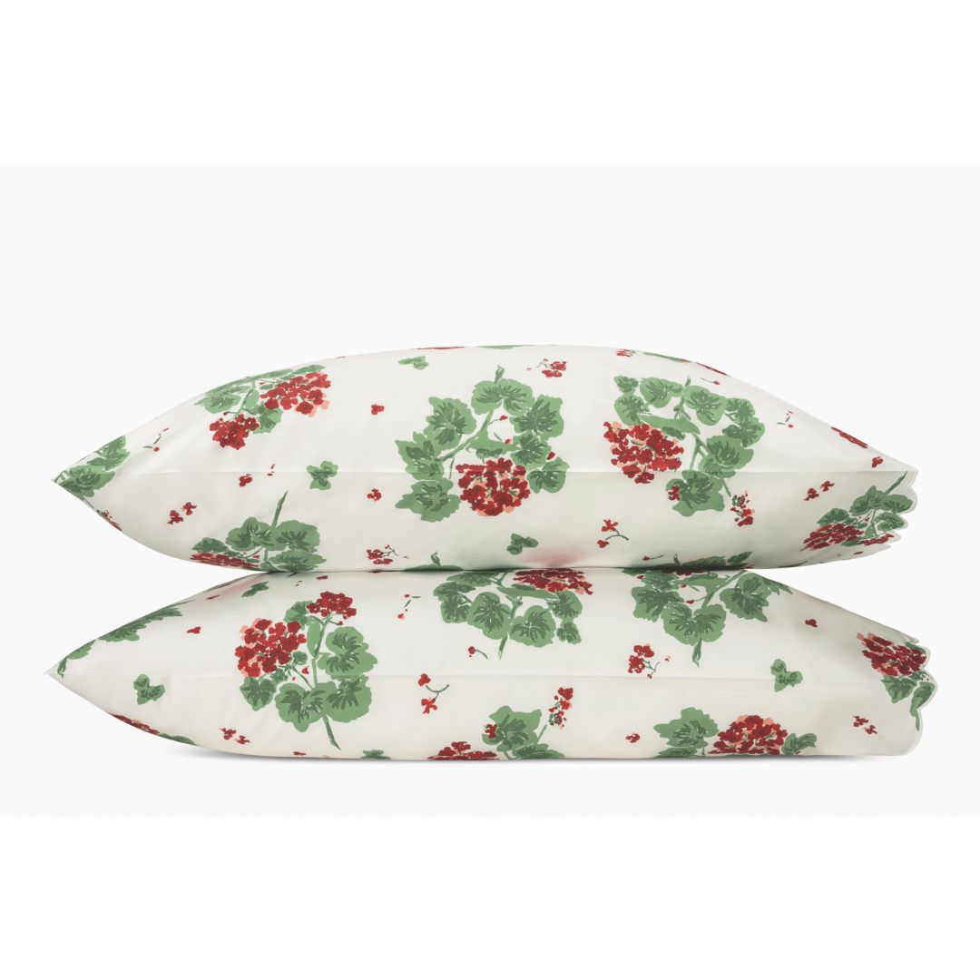 Two stacked pillows in the Matouk Tillett Geranium Collection with a botanical bedding floral print on white.