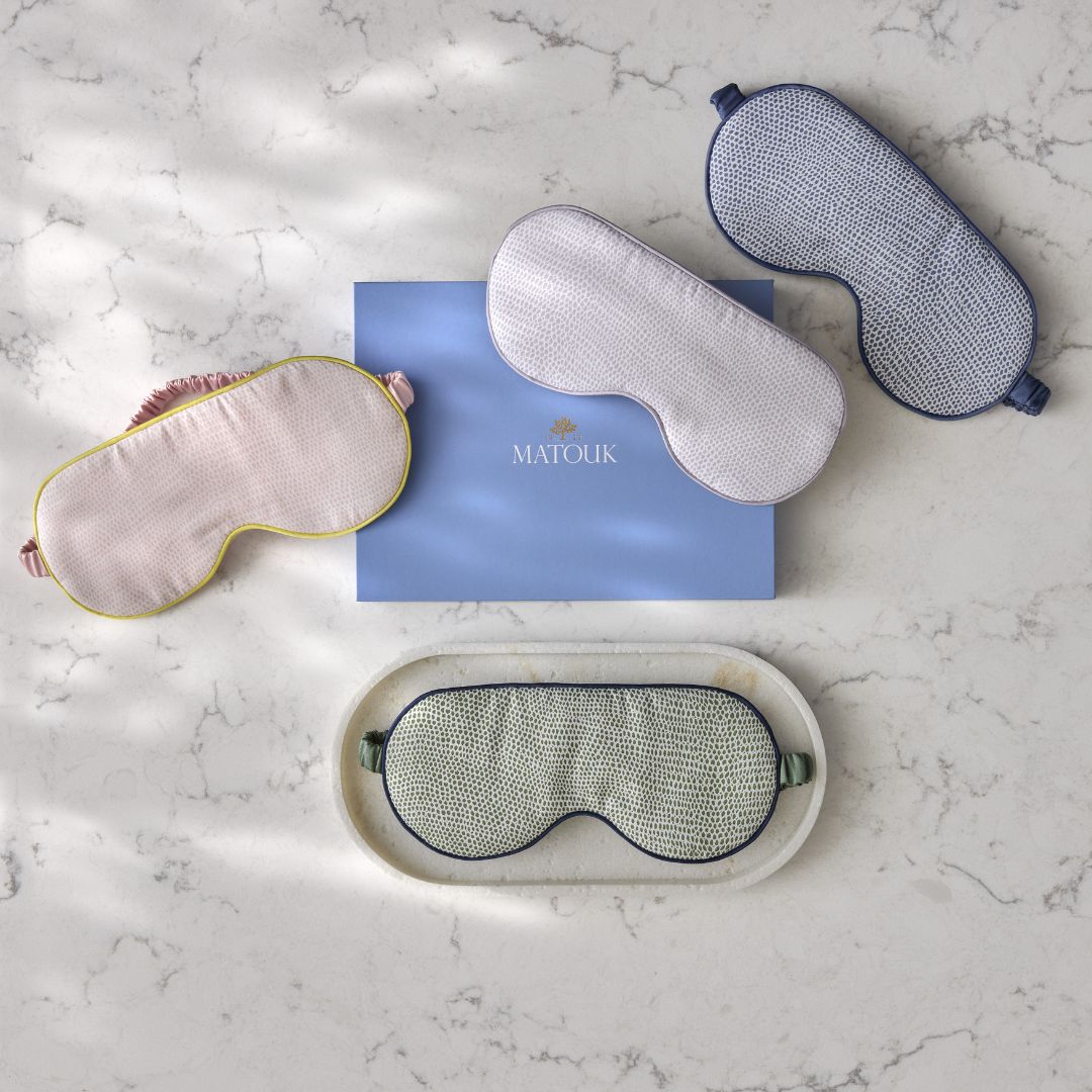 Set of four eye masks on a marble surface with a Matouk box.