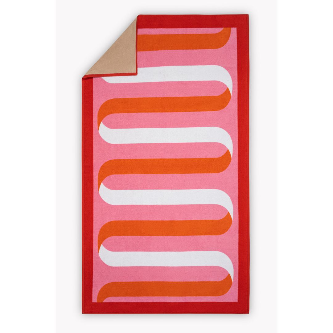 matouk ribbon beach towel in flamingo with corner folded back revealing tan reverse