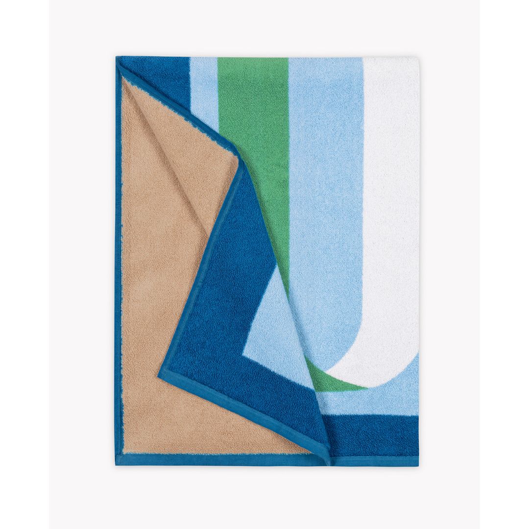 matouk ribbon beach towel in ocean showing the tan reverse