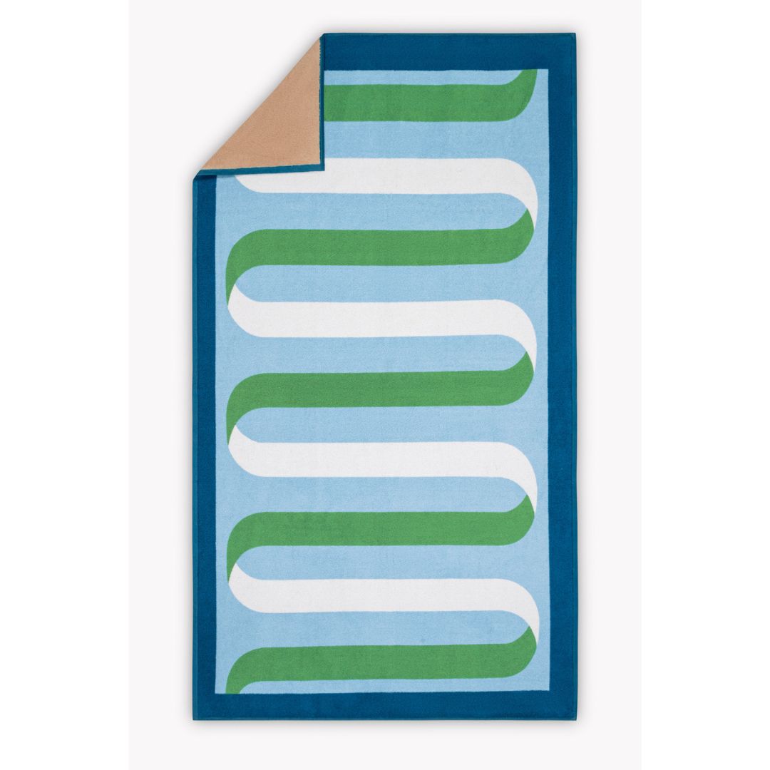 matouk ribbon beach towel with corner folded back revealing tan reverse
