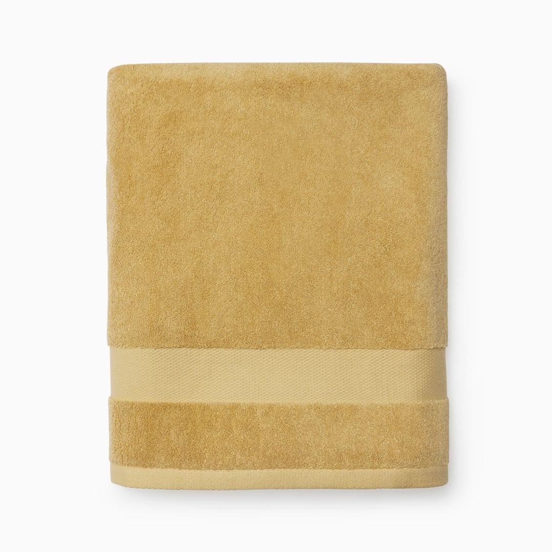 Folded yellow Sferra Bello Nuovo towel with a wide decorative band, crafted from long-staple combed cotton.