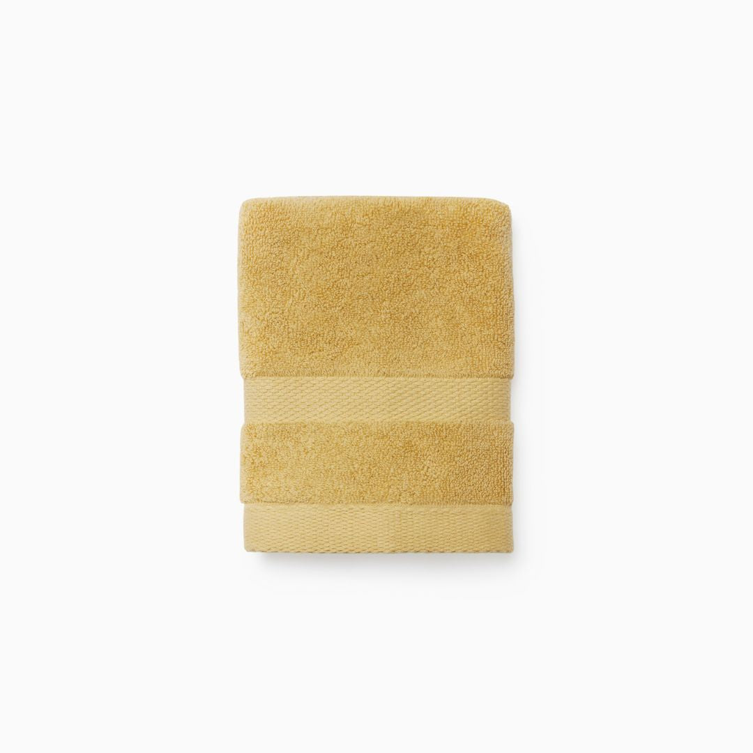 A neatly folded Sferra Bello Nuovo towel with textured bands, crafted from long-staple combed cotton, rests on white.