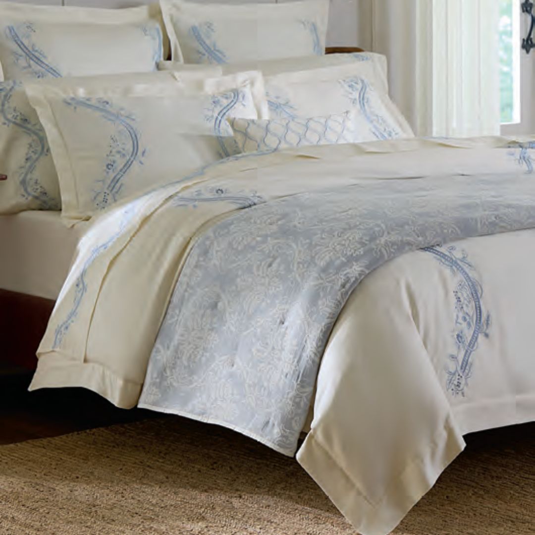 A neatly made bed with Sferra Isabella Bedding, luxury cotton sateen, and European-inspired embroidery on every detail.