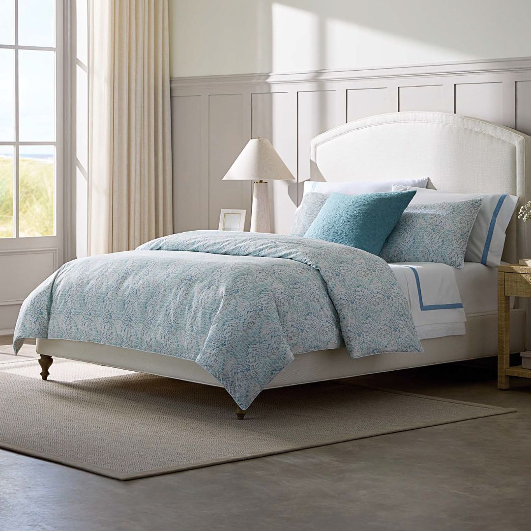 Bedroom with a bed featuring light blue bedding and pillows.