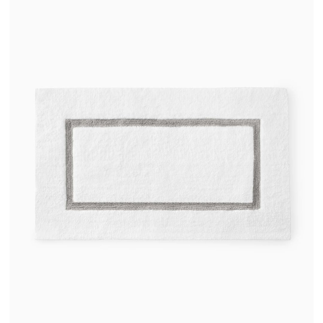 White cotton bath rug with a simple gray border, Sferra Lindo Bath Rug, shown on a plain white background.