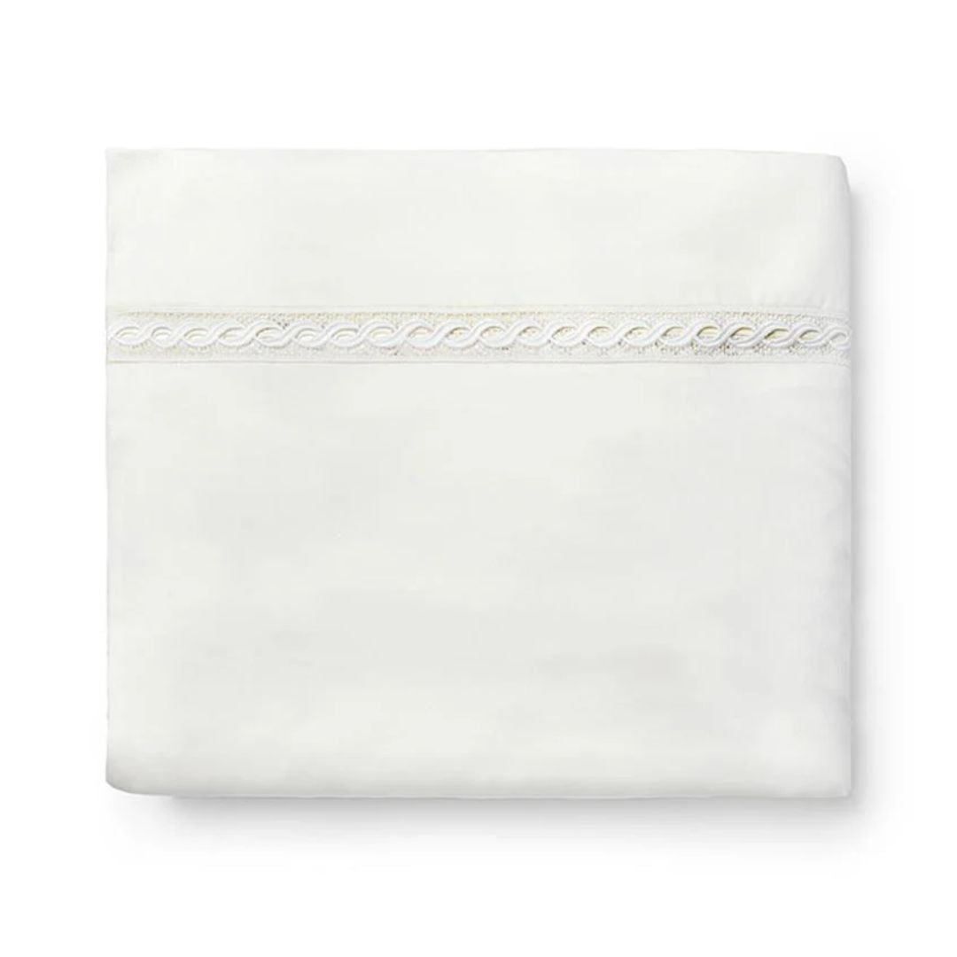 A folded white Sferra Millesimo sheet with lace trim, crafted from luxury Egyptian cotton sateen.
