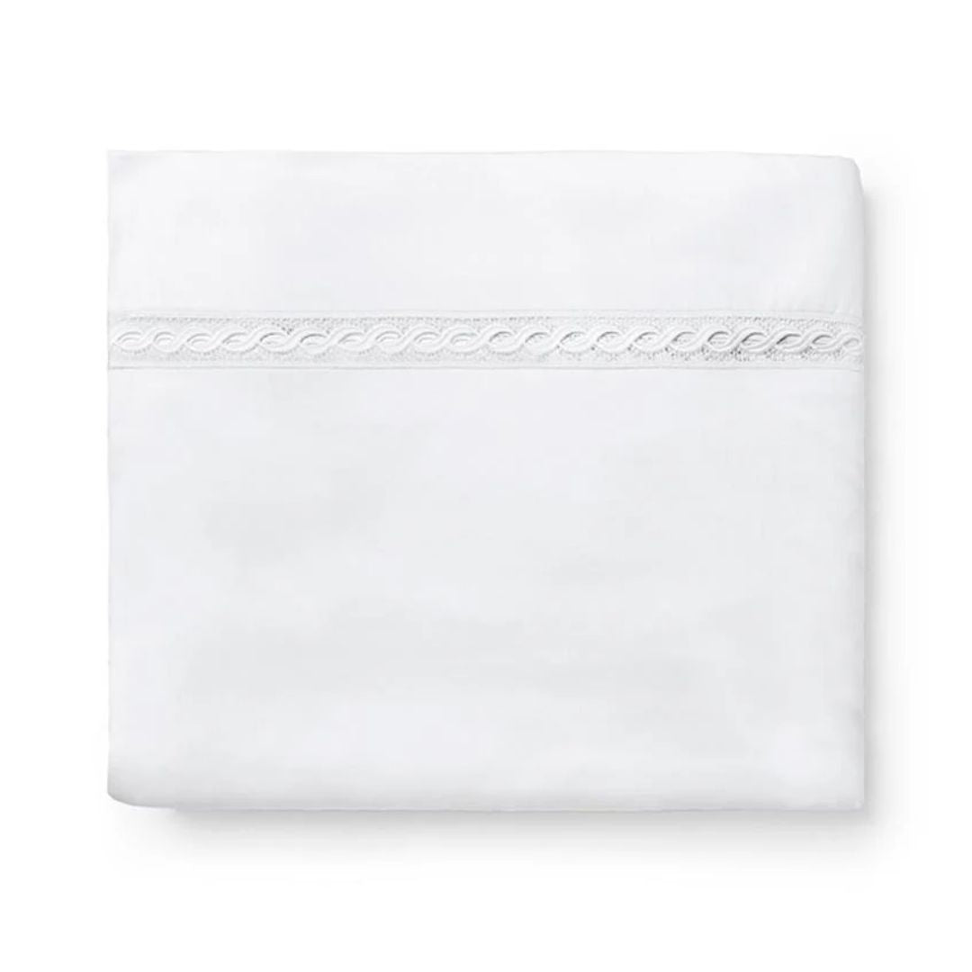 Folded white Sferra Millesimo bedding with lace trim, crafted from luxury Egyptian cotton sheets, on a plain white background.