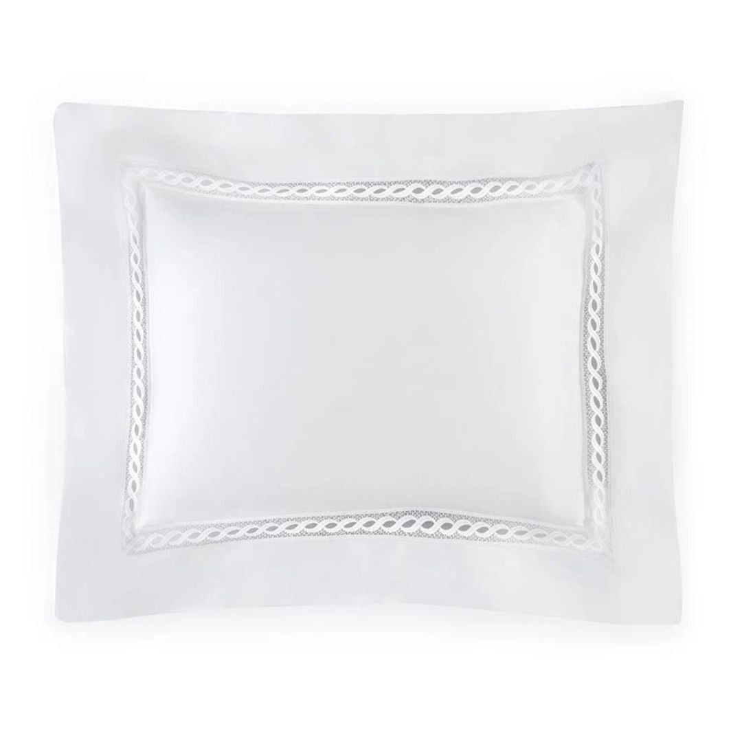 A white rectangular pillow with a lace border pairs beautifully with luxury Egyptian cotton sheets from Sferra Millesimo bedding.